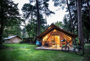 Camping La Pinède في إكسينيفيكس: خيمة فيها دراجة متوقفة امامها