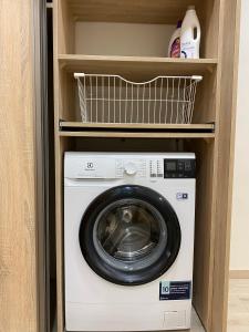 a washer and dryer sitting inside of a closet at Vakariniai Apartamentai in Panevėžys