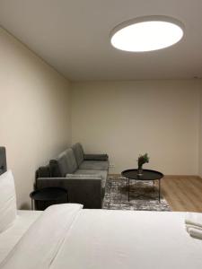 - un salon avec un canapé et une table dans l'établissement Vakariniai Apartamentai, à Panevėžys