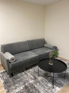 sala de estar con sofá y mesa en Vakariniai Apartamentai, en Panevėžys