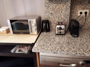a kitchen counter with a microwave and a toaster oven at Can Santa dúplex en el centro de Camprodón in Camprodon