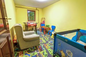 a childs play room with a chair and a crib at Willa pod Zegarem - w cenie Parking, szybkie Wifi, duzy ogrod, wiata grilowa! in Krynica Zdrój
