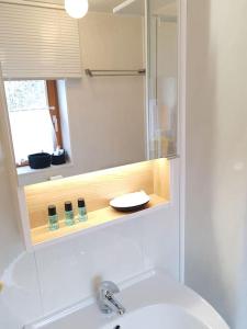 a bathroom with a sink and a shower with a mirror at Wohnung mit Balkon in Velden - Appartment BERGE byTILLY in Velden am Wörthersee