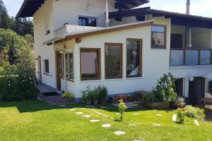 una casa con un cortile verde davanti di Wohnung mit Balkon in Velden - Appartment BERGE byTILLY a Velden am Wörthersee