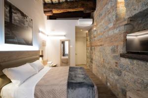 um quarto com uma cama e uma parede de tijolos em B&B Governo dei Nove em Siena