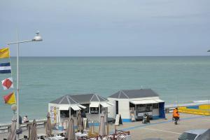 een gebouw op een strand naast de oceaan bij Les pieds dans l eau ! in Fécamp