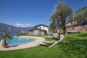a backyard with a swimming pool and a house at Villa Divina22 - APT Prima con piscina e vista lago in Castelletto di Brenzone