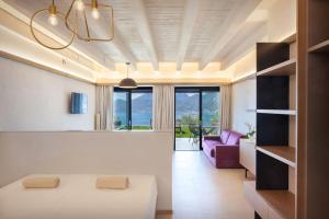 ein Schlafzimmer mit einem weißen Bett und einem lila Sofa in der Unterkunft Villa Divina - APT Prima con piscina e vista lago in Castelletto di Brenzone