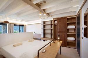 ein Schlafzimmer mit einem großen weißen Bett und Regalen in der Unterkunft Villa Divina - APT Prima con piscina e vista lago in Castelletto di Brenzone