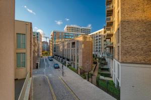 een lege straat in een stad met hoge gebouwen bij Austin David Apartments Royal Wharf in Londen