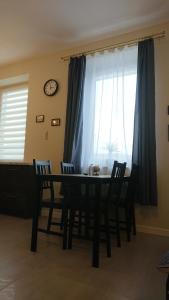 einen Esstisch mit Stühlen vor dem Fenster in der Unterkunft Apartament Pod Semaforem Duszniki-Zdrój in Duszniki-Zdrój + 3 Fotos
