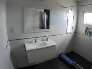 a white bathroom with a sink and a mirror at Buenos aires centro in Viedma