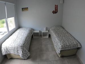 a bedroom with two beds and a table in it at Buenos aires centro in Viedma