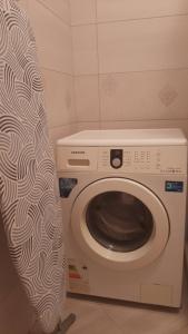 una lavatrice in un bagno con tenda doccia di Apartment in Serbska Lviv a Lviv