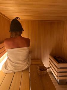 a woman is sitting in a sauna at Dom na Zielonym Wzgórzu z własną Sauną i Jacuzzi in Łapsze Niżne