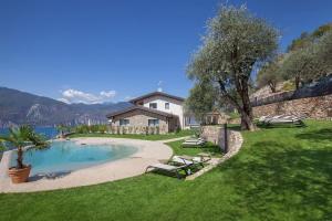 a backyard with a swimming pool and a house at Villa Divina - APT Divina con piscina e vista lago in Castelletto di Brenzone
