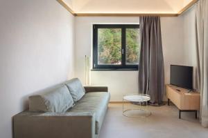 a living room with a couch and a television at Villa Divina - APT Divina con piscina e vista lago in Castelletto di Brenzone