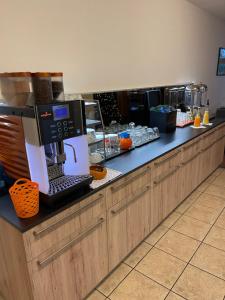 a coffee station with a coffee machine on a counter at Hôtel EDIROL in Vouvry