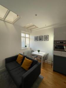 a living room with a black couch and a table at Gateforth Flat-Lovely 1 Bed in the heart of Central London in London