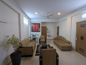 a living room with a couch and chairs and a table at The Altruist Business Stays B-2 in Bangalore