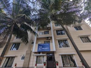 a building with palm trees in front of it at The Altruist Business Stays B-2 in Bangalore