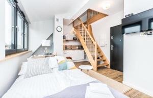 ein Wohnzimmer mit einer weißen Couch und einer Treppe in der Unterkunft KOŁOBrzegu Apartamenty by Jantar Apartamenty Kołobrzeg in Kołobrzeg