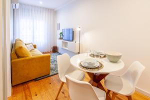sala de estar con mesa blanca y sillas en D&S - Crocodile House S. Bento Apartments, en Oporto