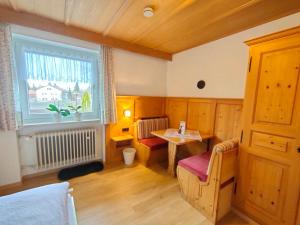 Habitación con cama, mesa y ventana en Gästehaus Sonnleit`n, en Lenggries