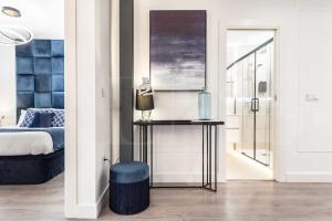 une chambre avec un lit et un tabouret bleu dans l'établissement Contemporary luxe duplex in the heart of Malaga by REMS, à Malaga 49 autres photos