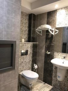 a bathroom with a toilet and a sink at Larimar Hôtel Sfax in Sfax