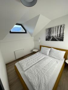 a bedroom with a white bed in a attic at Sunshine Apartments Golte C1 in Mozirje