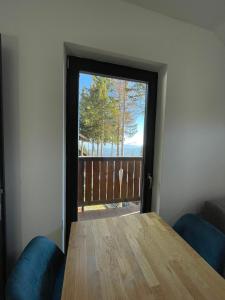 Pokój z drewnianym stołem i drzwiami z widokiem w obiekcie Sunshine Apartments Golte C1 w mieście Mozirje