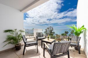 a balcony with chairs and tables and a view of the ocean at Bahia de Torrequebrada - 2 Bedroom Apartment with Seaview in Benalmádena