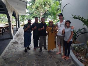 a group of people posing for a picture outside a house at La Collina Villa in Jepara