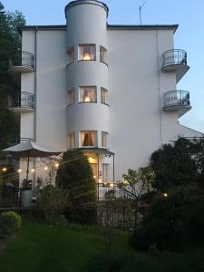 a white building with balconies on the side of it at Willa Urocze in Muszyna