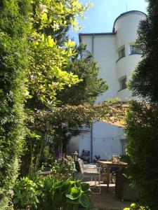 a garden with a table and chairs in front of a building at Willa Urocze in Muszyna