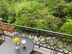 a table with two candles and a vase of flowers on a balcony at PORDANİS HOTEL in Çamlıhemşin