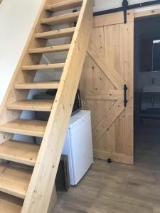 uma escada de madeira com uma porta numa cozinha em Natuurhuisje Gouderak em Gouderak
