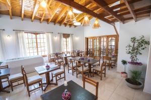 a restaurant with tables and chairs and windows at PUNTO SUR HOTEL BOUTIQUE in Malargüe