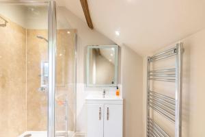 a bathroom with a shower and a sink and a mirror at The Granary at Hawkhurst in Craven Arms