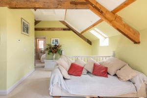 una sala de estar con un sofá blanco con almohadas rojas en The Granary at Hawkhurst en Craven Arms