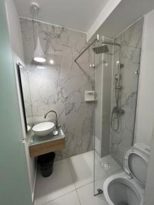 La salle de bains est pourvue d'une douche, d'un lavabo et de toilettes. dans l'établissement TOURIST HOTEL, à Chimkent