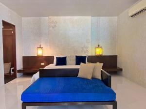 a bedroom with a large bed with a blue cushion at Koh Kwang Beach Resort in Ban Ko Kwang