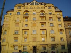 ブダペストにあるDanube Viewの多くの窓のある黄色の建物