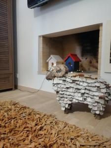 a room with a stone fireplace with birds and houses at Lumen 1-bedroom apartment in the heart of Trikala in Tríkala