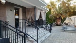 a building with stairs and chairs and a palm tree at Hotel Rodos in Adler