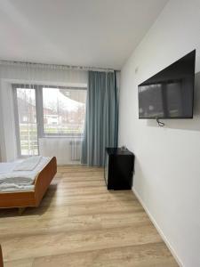 a bedroom with a bed and a flat screen tv at TOURIST HOTEL in Shymkent