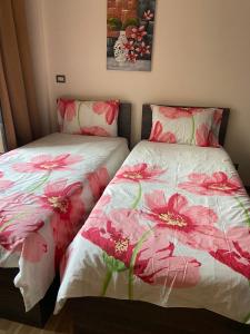 two beds sitting next to each other with pink flowers at Families Only - Rehab - 4th Stage - Ground Floor with Garden in Cairo