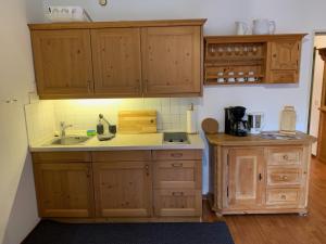 una cocina con armarios de madera y fregadero en Almzeit, en Farchant