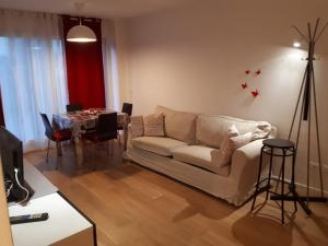 een woonkamer met een witte bank en een tafel bij B&b Campus in Parma